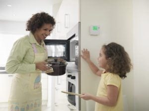Mother and daughter cooking in energy efficient house